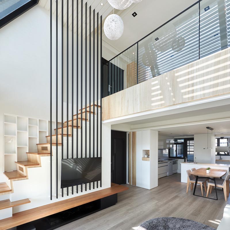 Interior design firm INDOT has designed a modern apartment in Taiwan, that features a bold collection of 12 black poles that travel from the living room up to the high ceiling. #HighCeiling #TVMount #StairDesign
