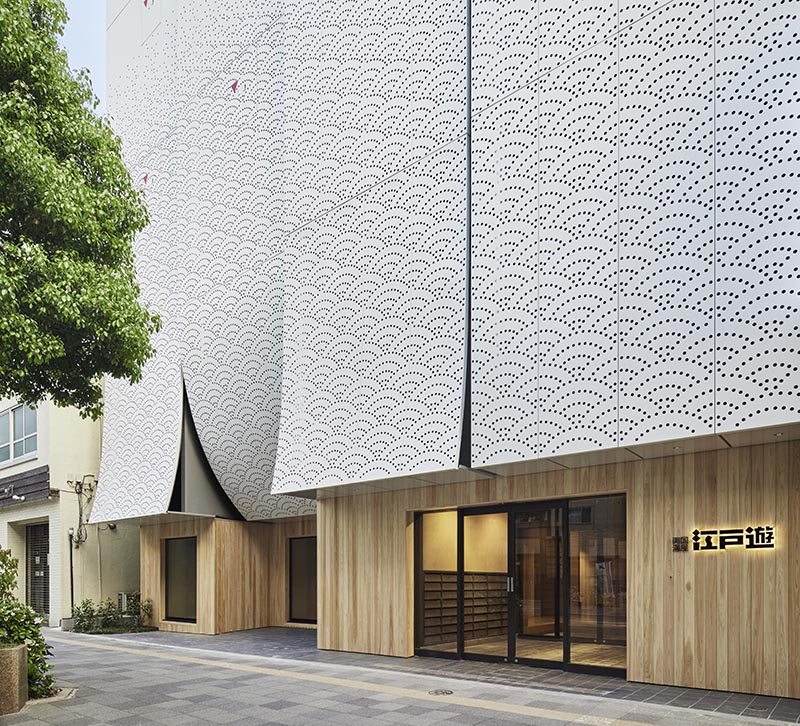 Kubo Tsushima Architects has designed Ryogoku Yuya Edoyu, a spa facility in Tokyo, Japan, that showcases an artistic facade of perforated aluminum in a traditional Japanese pattern. #ArtisticFacade #BuildingFacade #PerforatedAluminum #Architecture