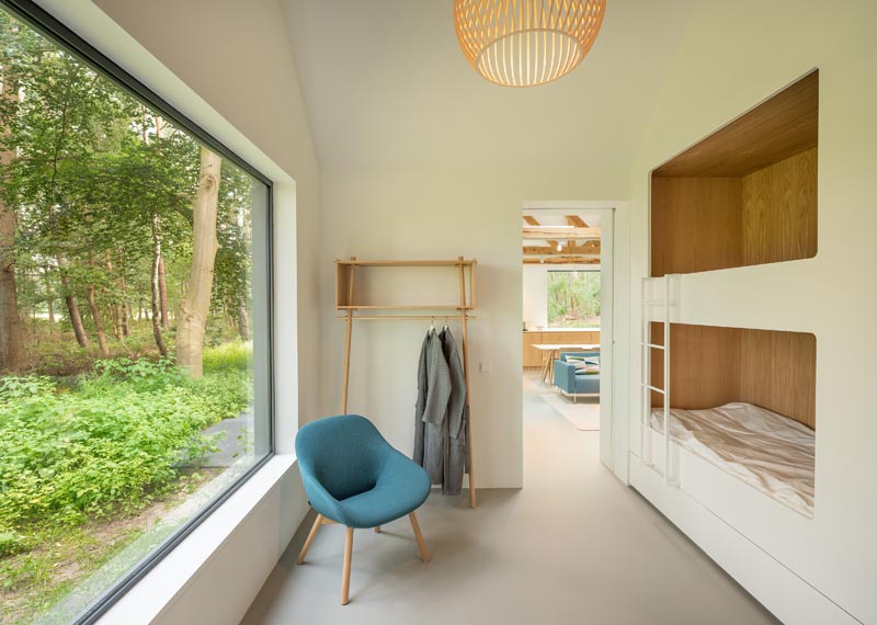 This modern children's bedroom has built-in wood-lined bunk beds and a large picture window. #BunkBeds #BuiltInBunkBeds #ChildrensRoom #KidsRoom #Windows