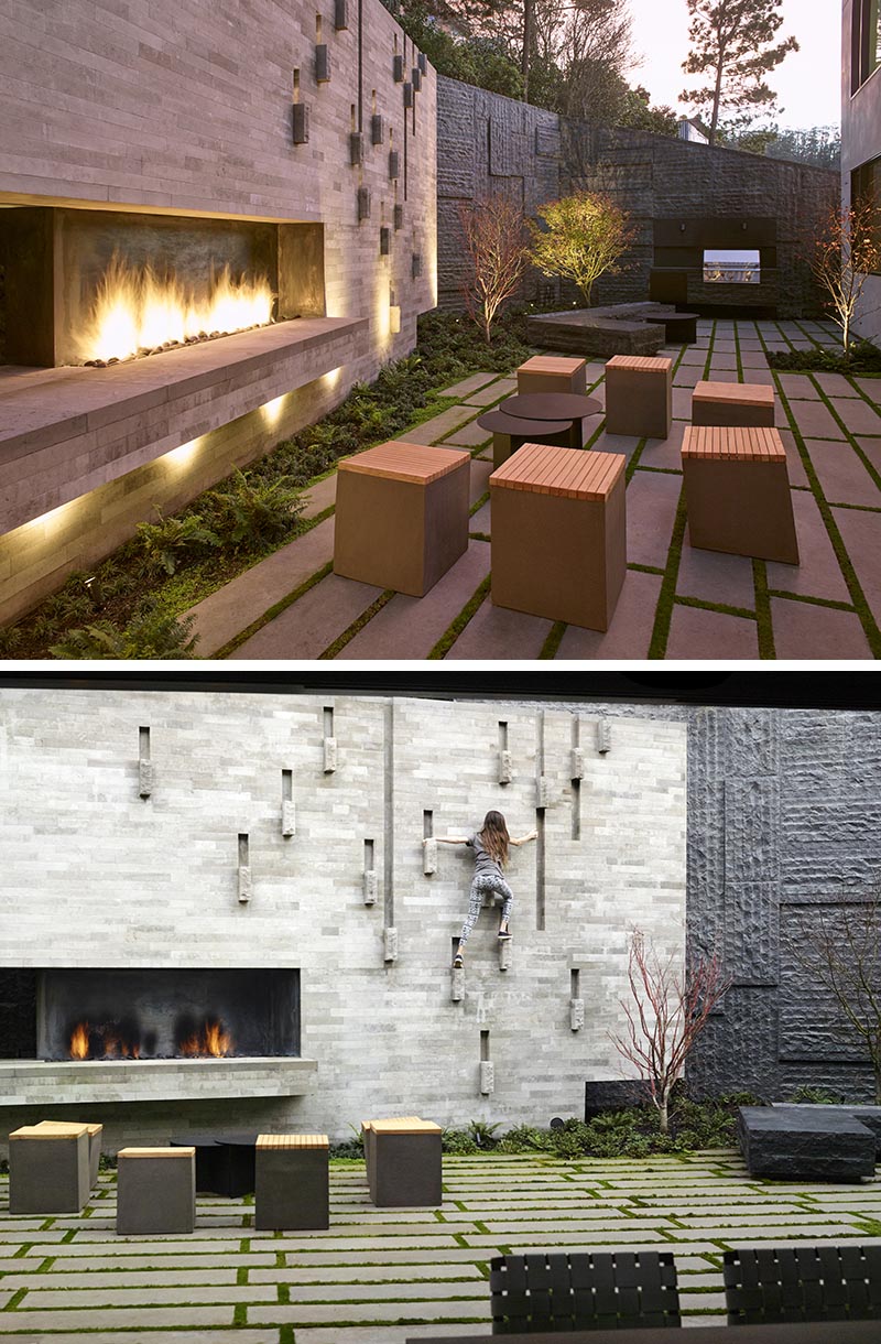 This modern courtyard has Basalt-clad retaining walls that hold back the hillside and frame the courtyard, while the limestone hearth anchors the garden, and a panel of blackened steel creates a backdrop for a built-in barbeque. #LandscapeDesign #Landscaping #Courtyard #RetainingWalls #OutdoorFireplace