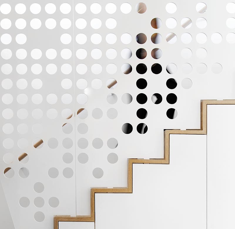 In keeping with the mostly white interior of this modern apartment, a custom white perforated metal guardrail screen was designed for the stairs, creating a playful shadow effect that changes throughout the day. #GuardrailScreen #Stairs #StairDesign #ModernStairs