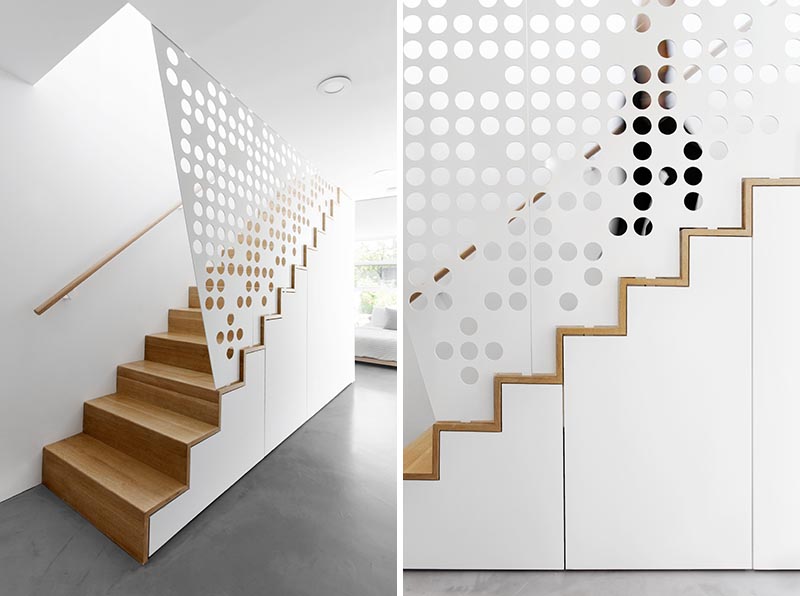 In keeping with the mostly white interior of this modern apartment, a custom white perforated metal guardrail screen was designed for these wood stairs, creating a playful shadow effect that changes throughout the day. #GuardrailScreen #Stairs #StairDesign #ModernStairs #Screen #PerforatedScreen