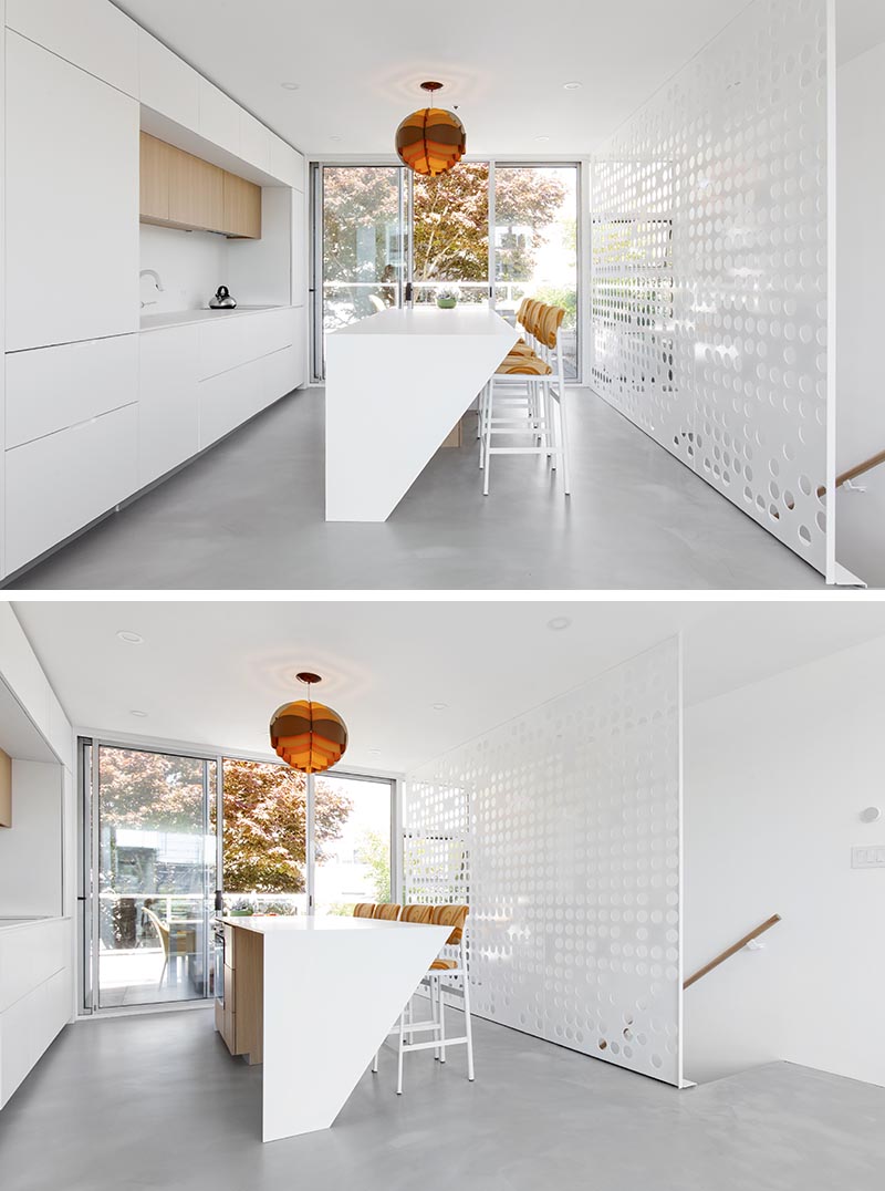 A custom white perforated metal guardrail screen was designed for this modern apartment. It doubles as a minimal and artistic backdrop for the kitchen. #GuardrailScreen #Stairs #StairDesign #ModernStairs #Screen #PerforatedScreen