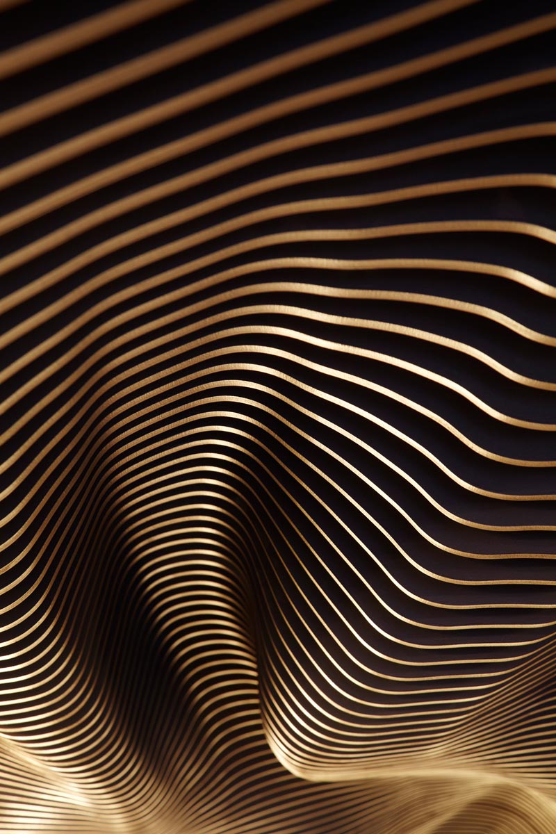 This undulating ceiling installation is composed of laser cut MDF fins with a black finish. #SculpturalCeiling #CeilingInstallation #Sculpture #RestaurantDesign
