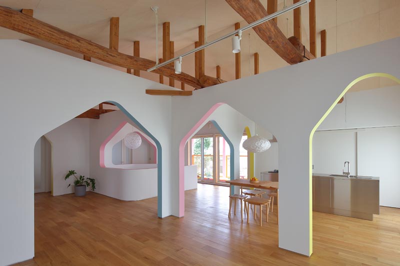 This modern home / design studio features bright white walls with arches that have accentuated with soft blues, yellows, and pinks. #InteriorDesign #Arches #InteriorArches #WhiteWalls