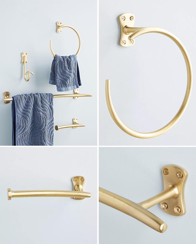 This modern brass bathroom hardware collection includes a towel bar, wall hook, toilet paper holder, and towel ring.