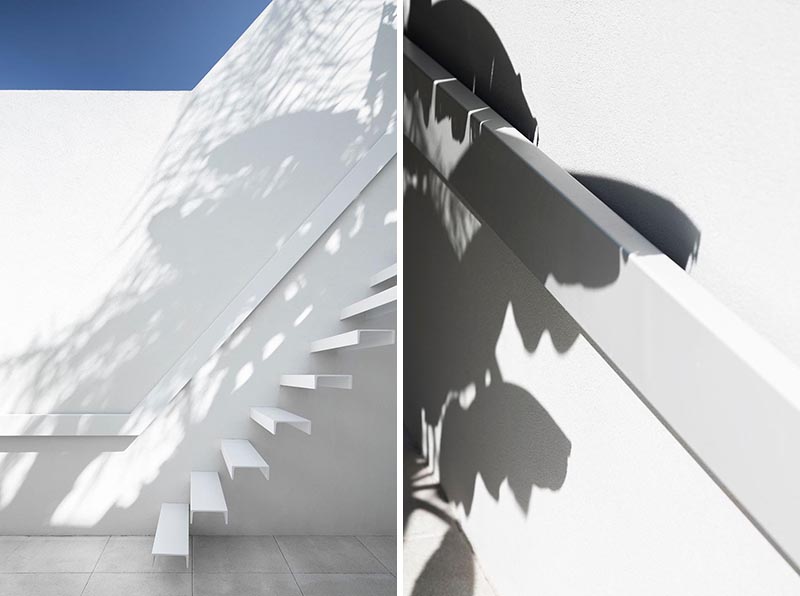 White cantilevered stairs with matching white handrail.