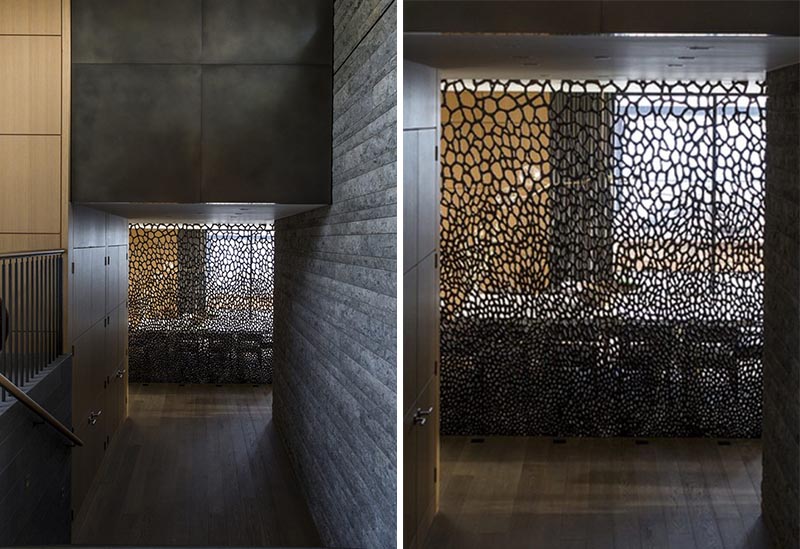 An artistic and sculptural bronze screen separates the dining room from the stairs.