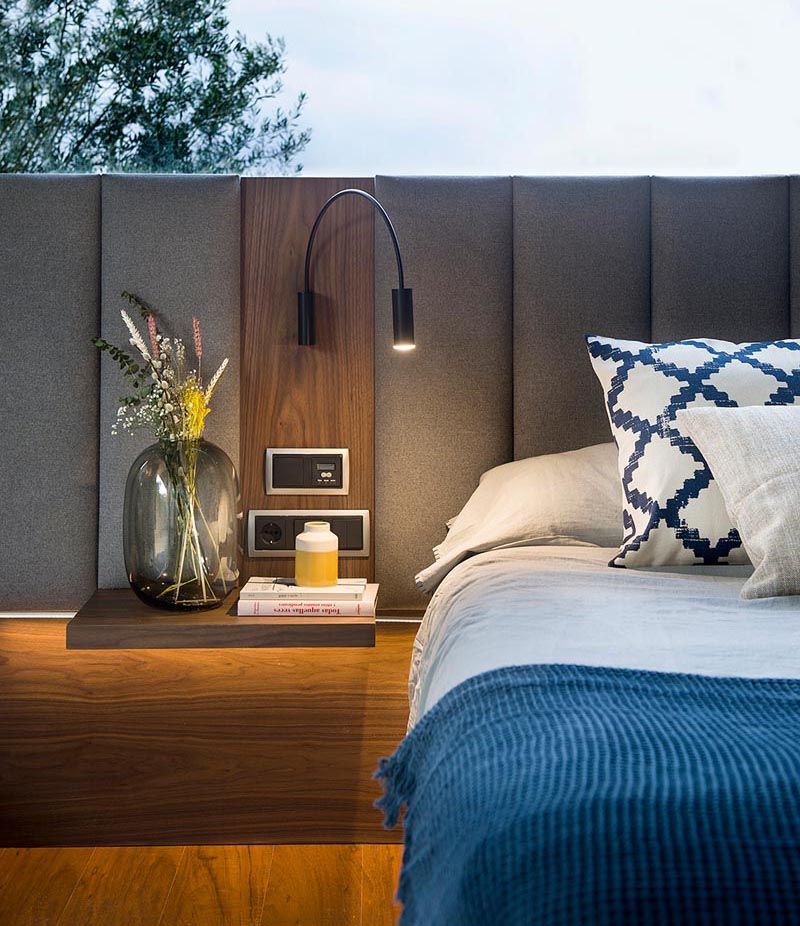 A grey and wood upholstered headboard for a modern master bedroom.