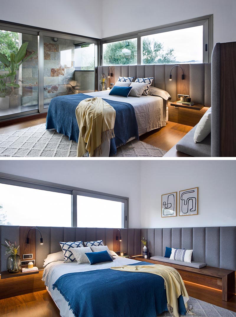 A modern master bedroom with a grey upholstered headboard.