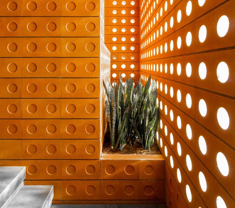 Custom designed modern bricks with small round windows and circular indents were used to create a buildling in Tehran.