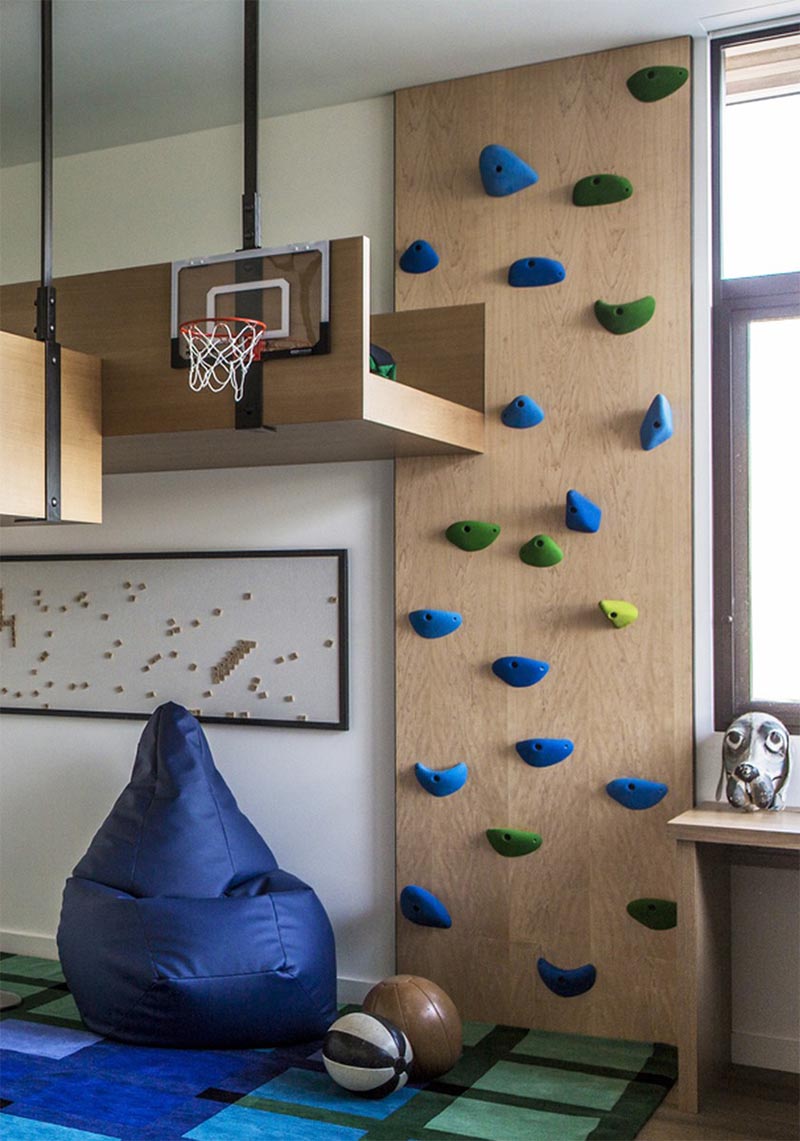 A fun kids bedroom with a rock climbing wall.