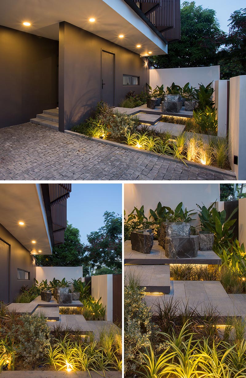 A front garden with hidden lighting that showcases the layered steps, seating area, and lush landscaping.