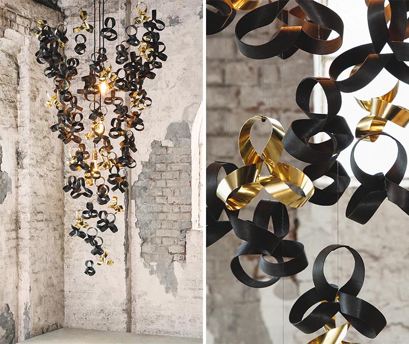 An artistic chandelier made from curls of ebonised oak, ebonised tulip wood, and reflective solid brass.