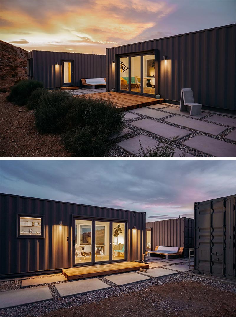 A modern shipping container house that's made from three separate containers and is painted dark grey.