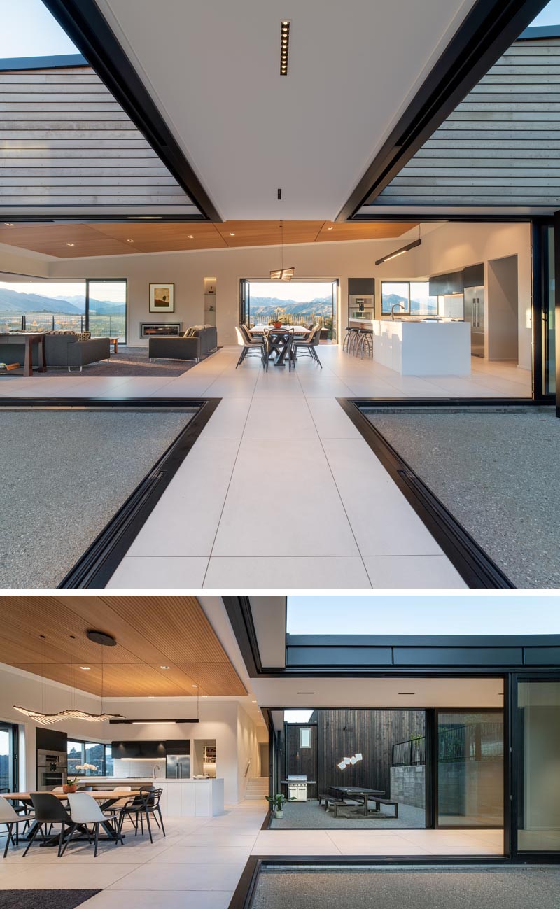 Retractable glass walls connect the interior spaces of this house with an alfresco dining area and a patio.