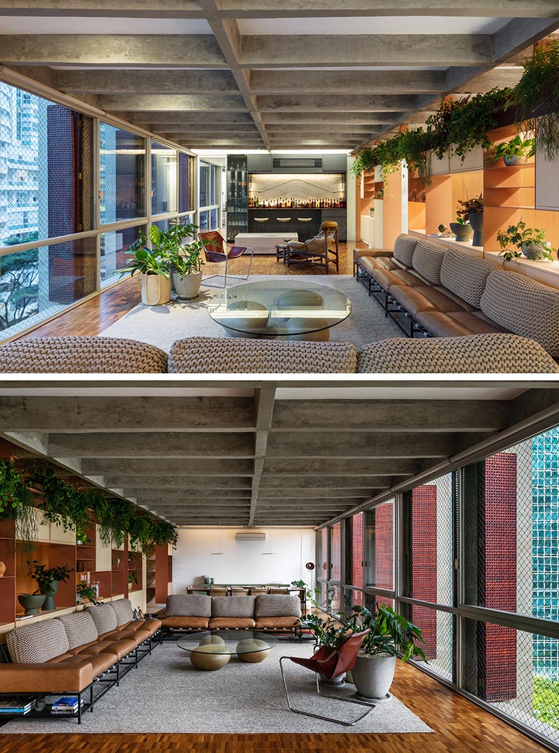 Plants cascade over a movable shelving unit in this apartments living room.