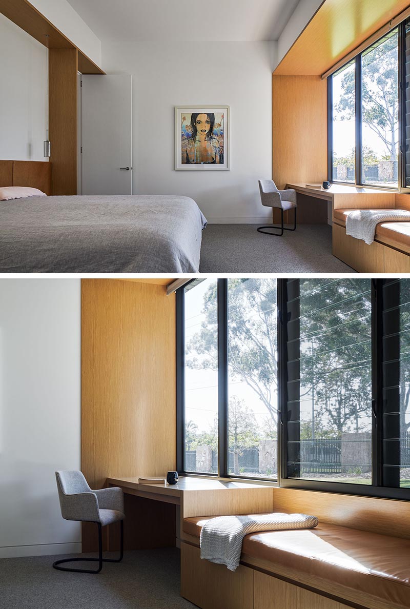 A modern bedroom with a built-in desk and window seat.