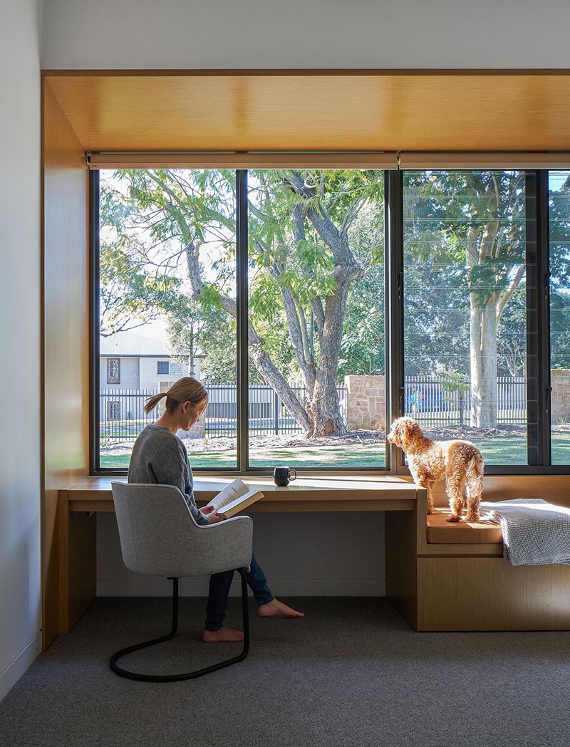 A wood-lined built-in desk and bench are positioned next to a window.