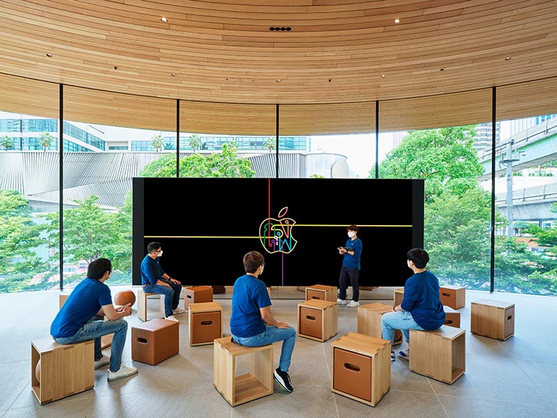 Apple Central World in Bangkok has a curved glass facade with a wood ceiling.