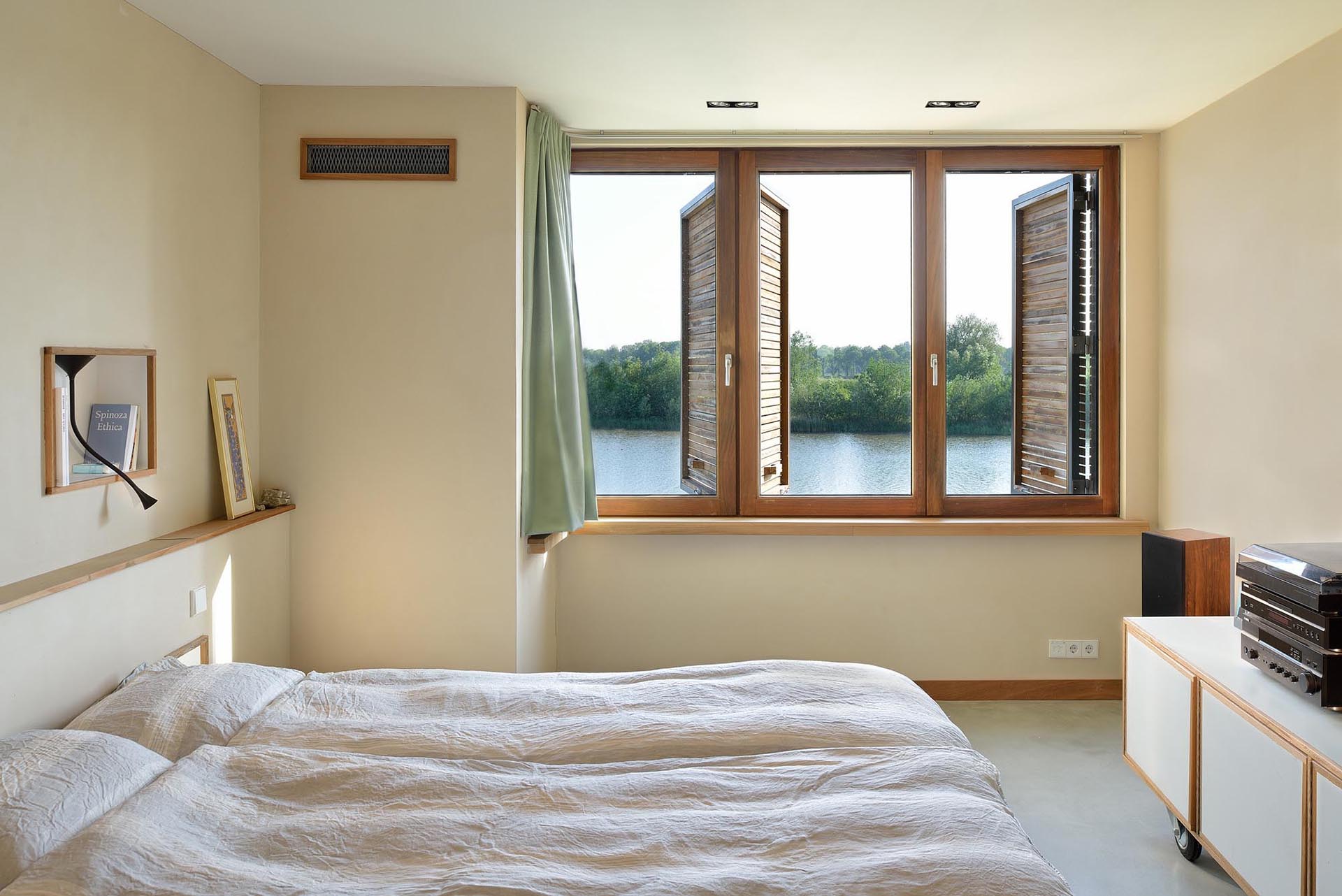 A neutral bedroom with wood window shutters.