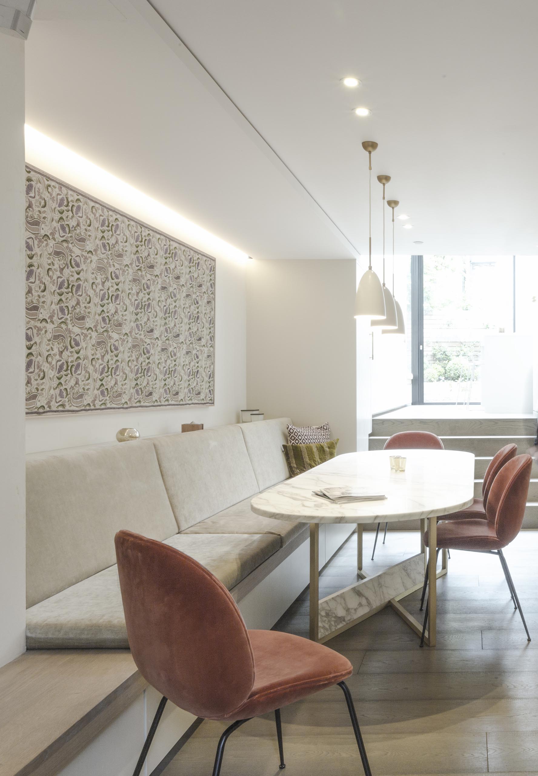 A custom built-in bench and curved dining table create a relaxed dining area.