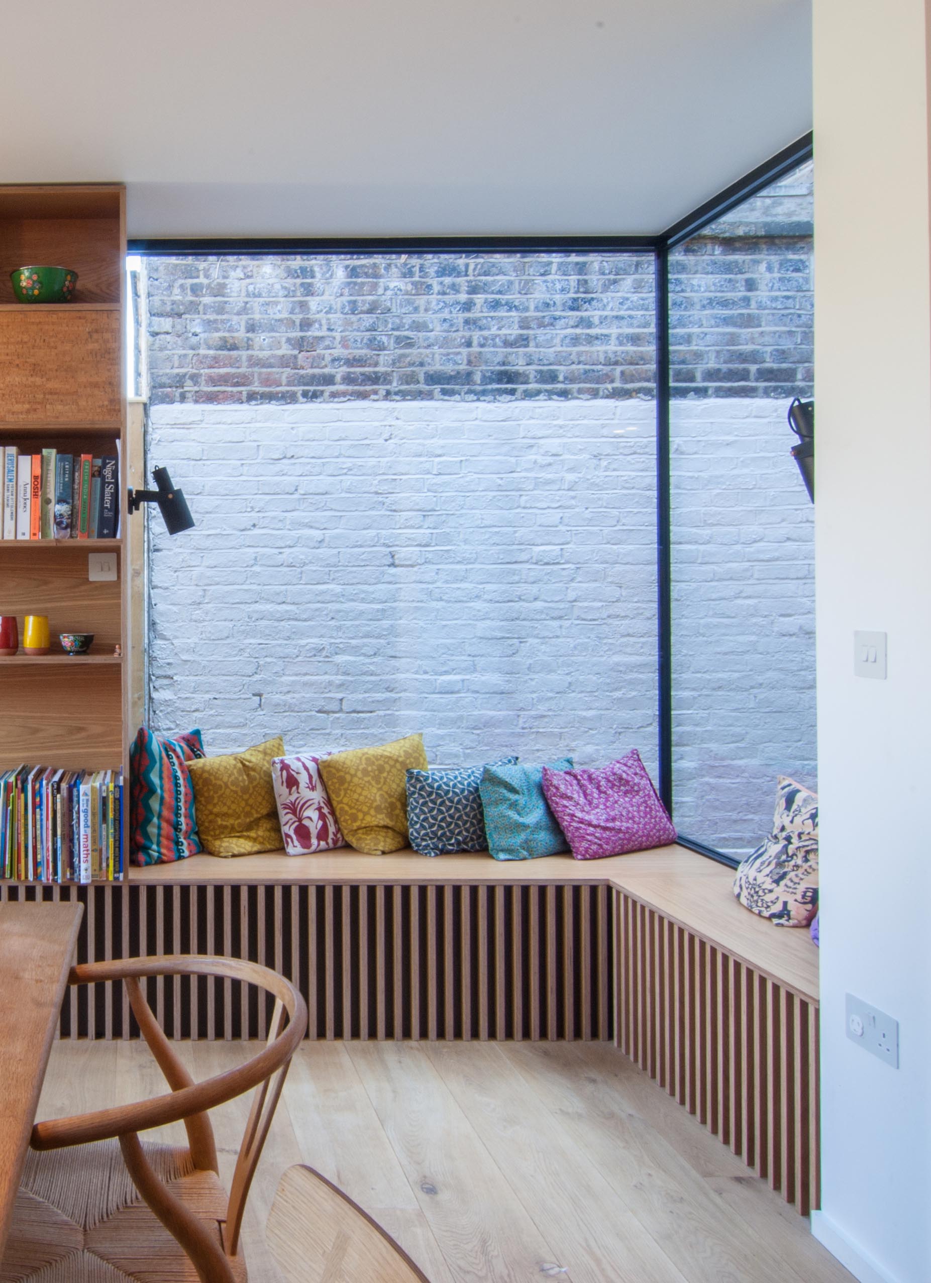 A corner window bench with colorful cushions