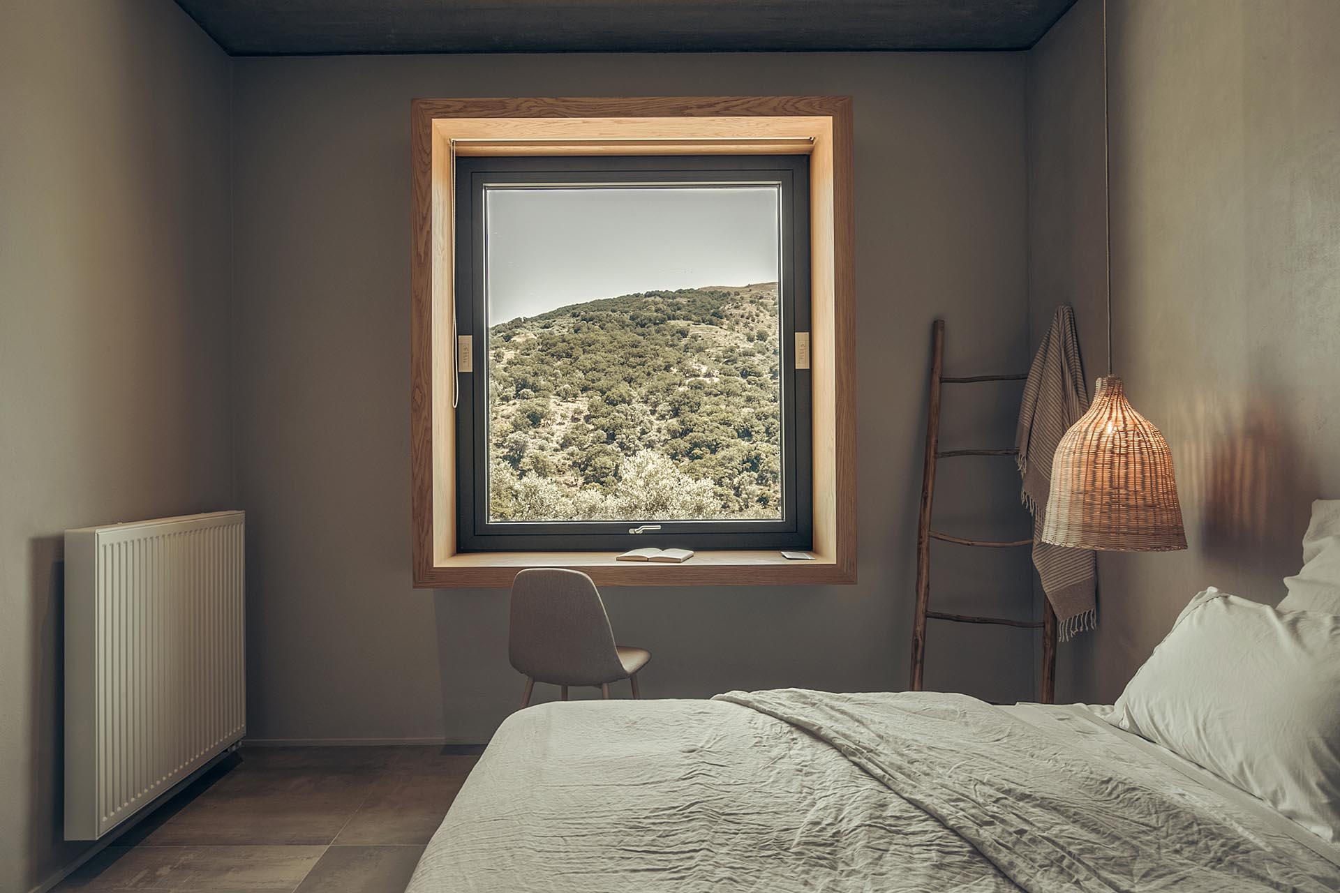 A deep wood window frame showcases the view and acts as a desk.