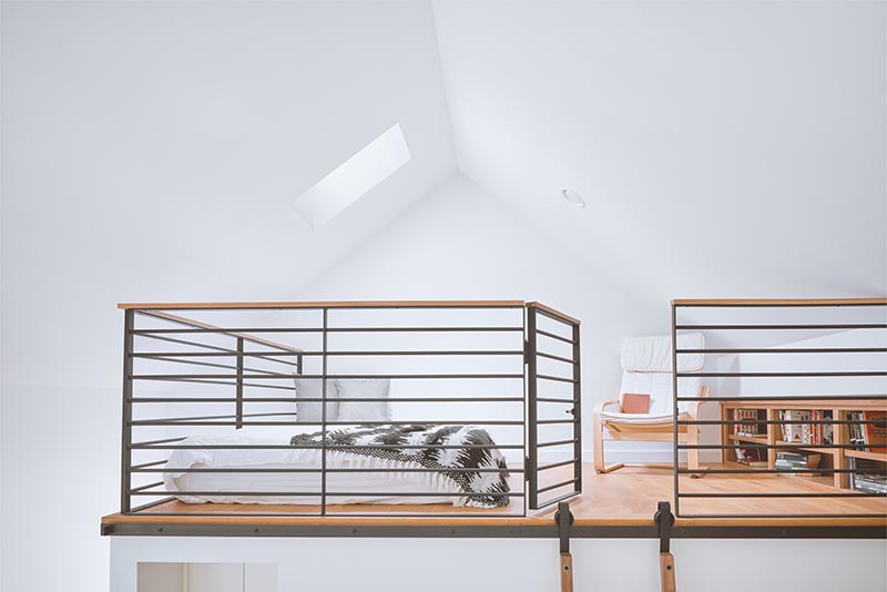 A lofted guest suite within a home office designed as a writer's studio