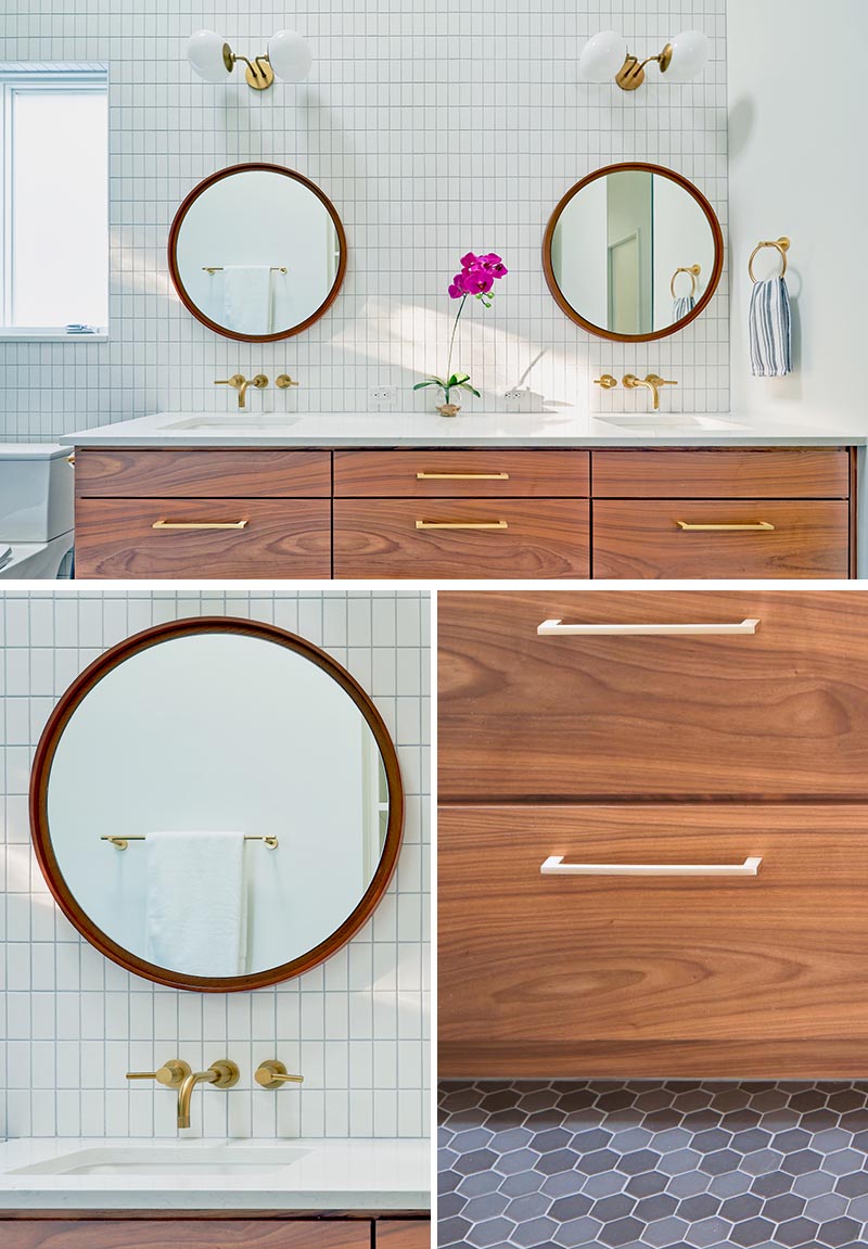 A modern bathroom with a wood vanity, gold accents, white tiles, and round mirrors.