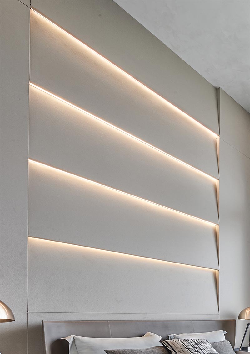 An accent wall with angled sections that also have hidden lighting that creates a soft glow.