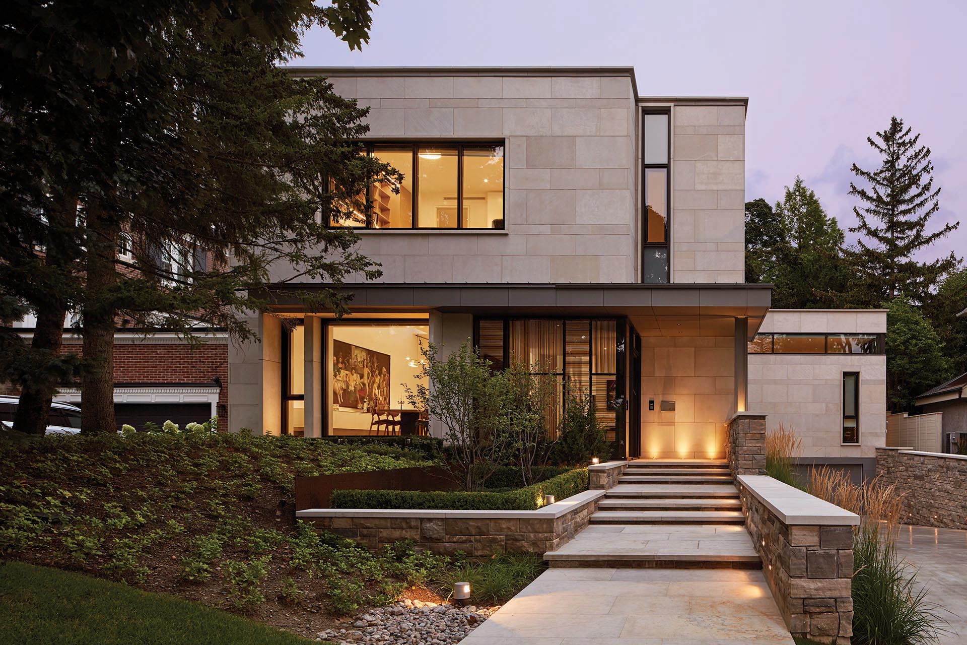 Indiana Limestone and split faced Ontario Algonquin stone clad the exterior of this modern house.