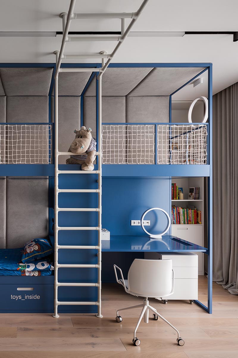 A kids bedroom with a climbing gym, homework station, and a lofted play space.