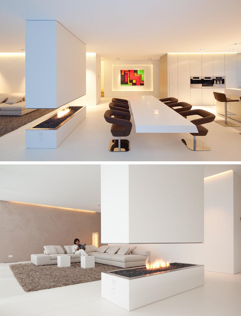 A minimalist room divider with a gas fireplace and contrasting black rocks.