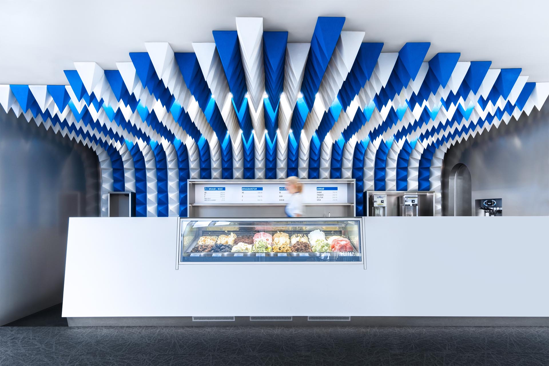 A sculptural ceiling installation made from blue and white foam pyramids.