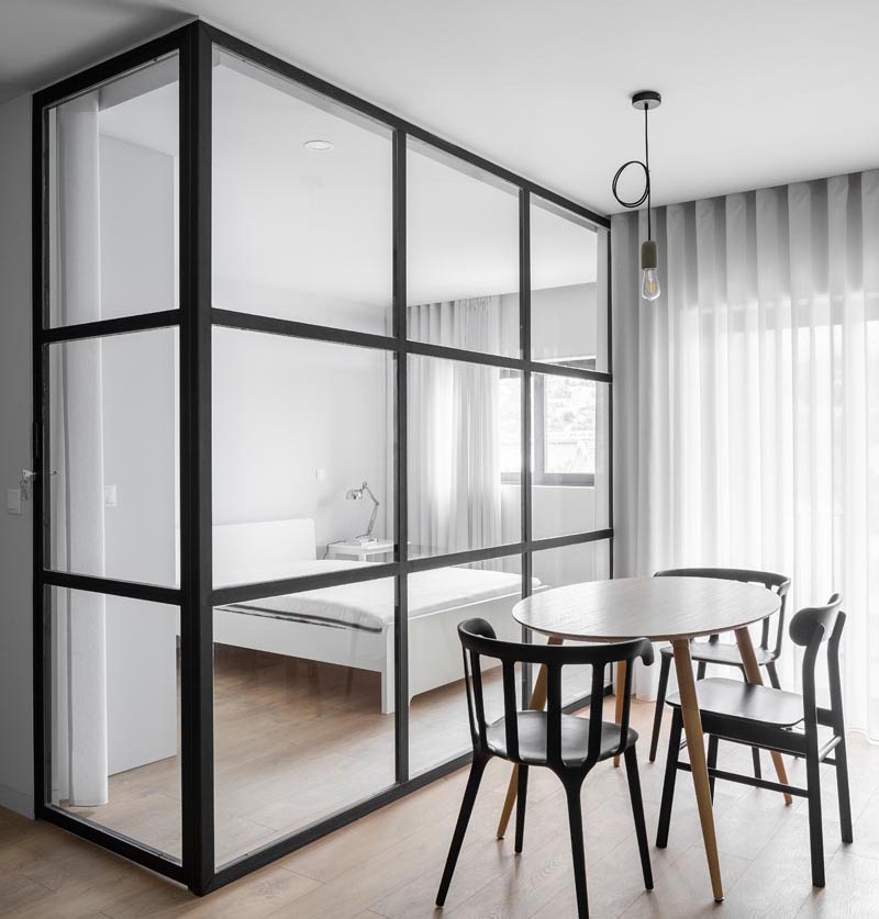 A Glass Enclosed Bedroom Allows Light To Travel Freely In This Small Apartment