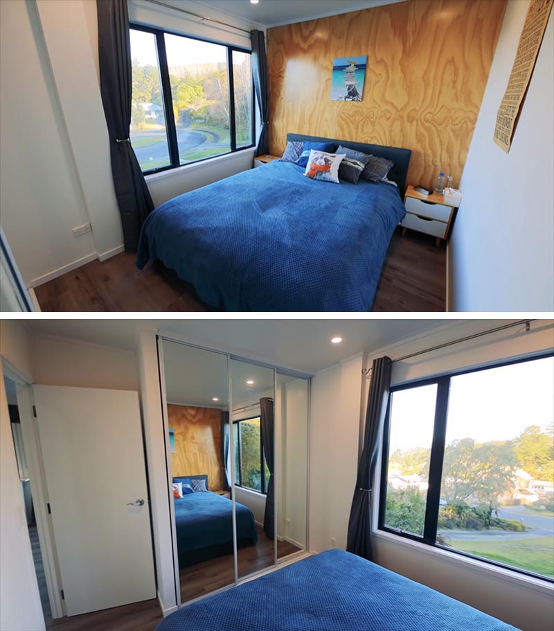 A small bedroom in a shipping container house has a plywood accent wall.