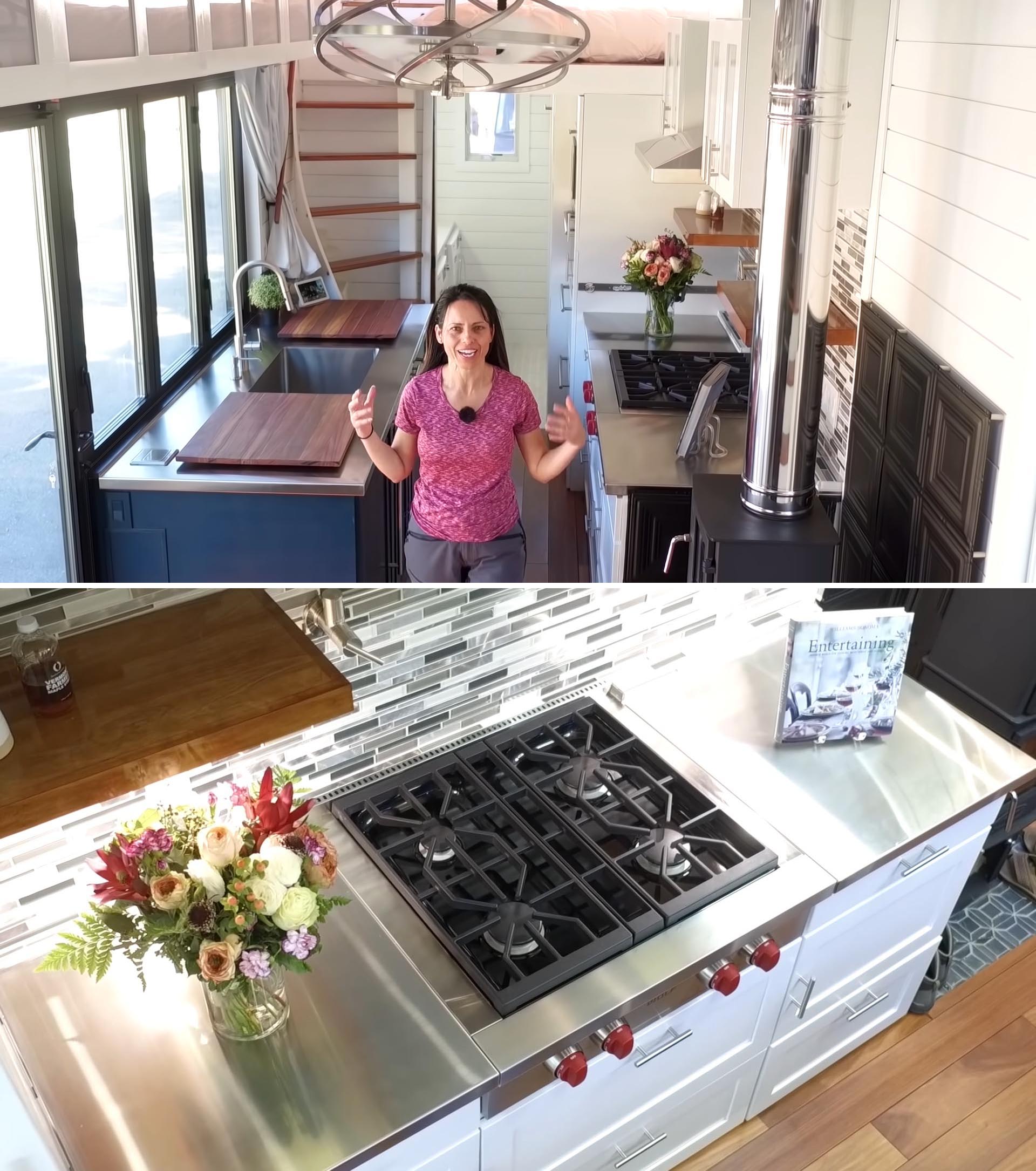 A tiny house kitchen with stainless steel countertops, full-size appliances, tile backsplash, and wood burning stove.