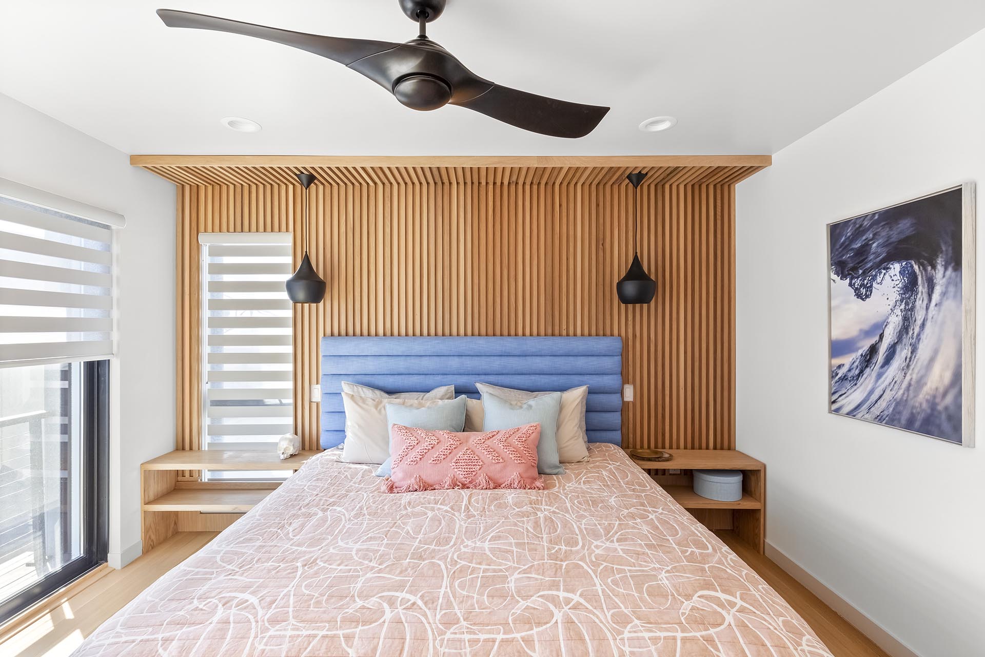 A wood accent wall in this modern bedroom has vertical slats to add a sense of height to the room.