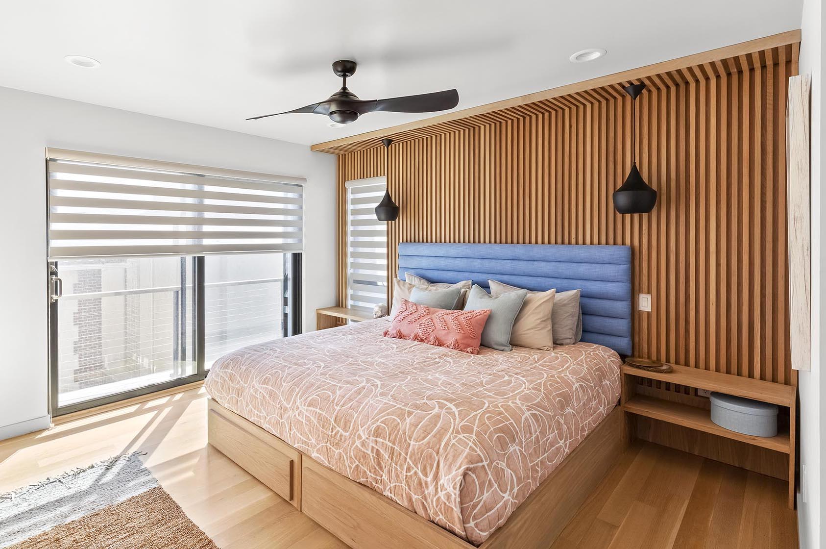 A modern bedroom with a wood accent wall.