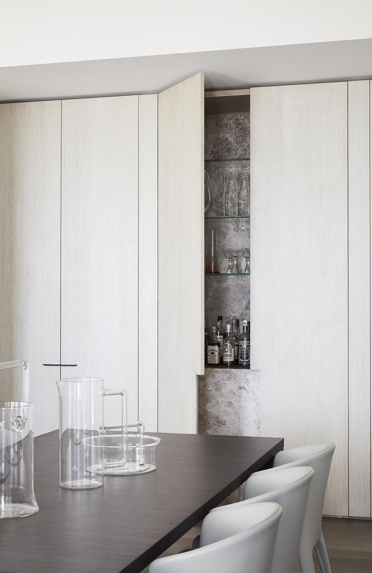 A bar hidden within a minimalist cabinet in the dining room.