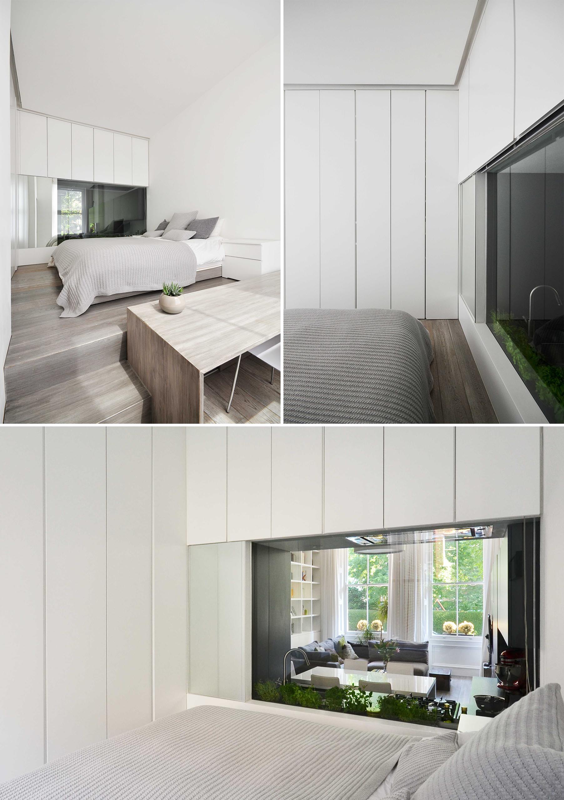 A bedroom with a window that looks through to the kitchen.