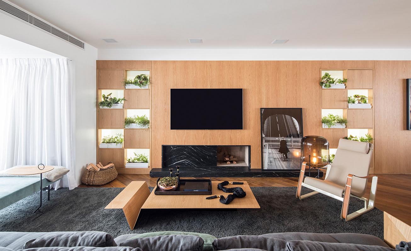 A wood living room wall with a fireplace and open shelves for small plants.