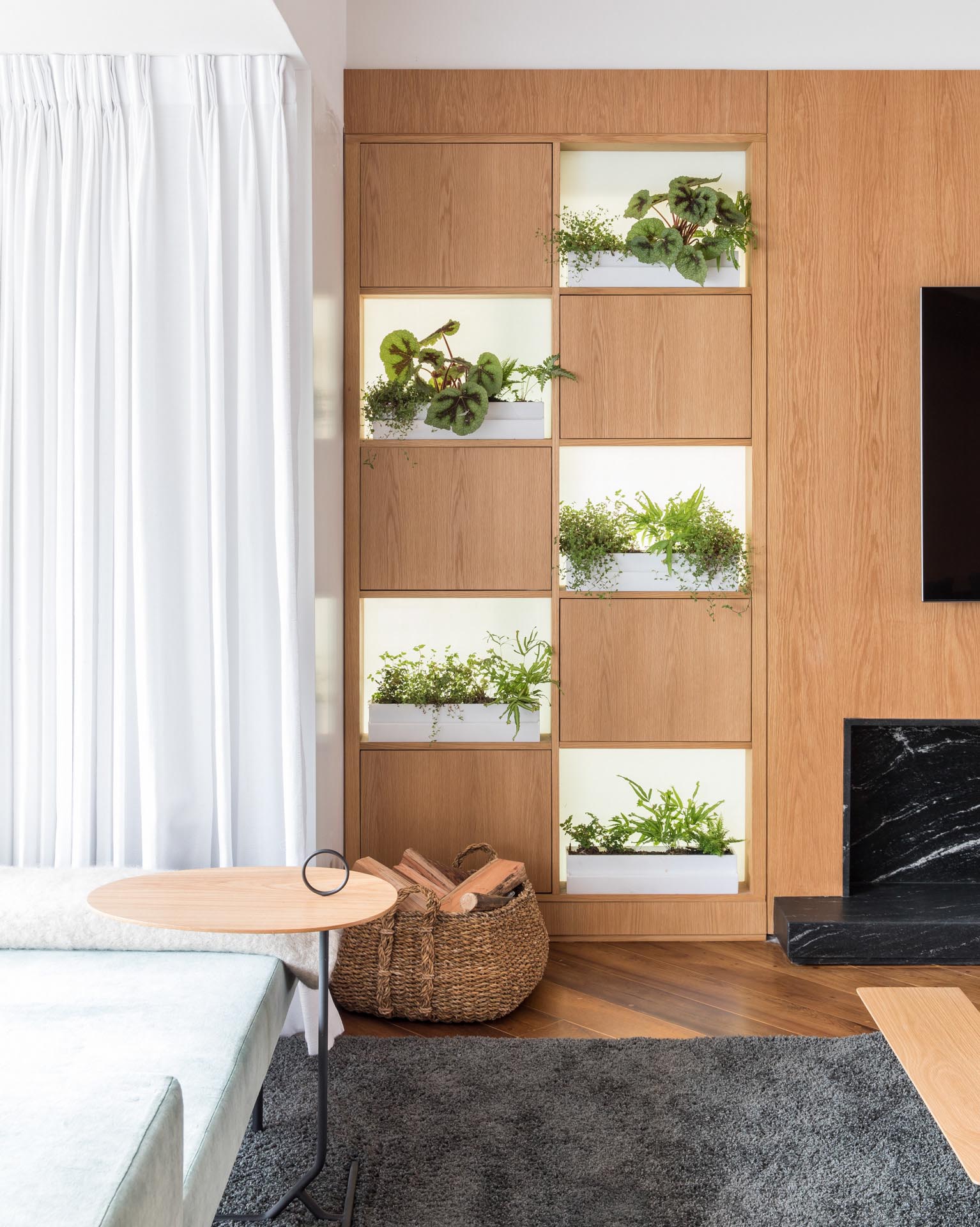 Small planters sit on open shelves within a wood wall.