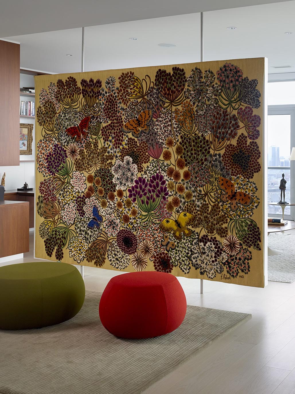A floating room divider that displays a large tapestry.