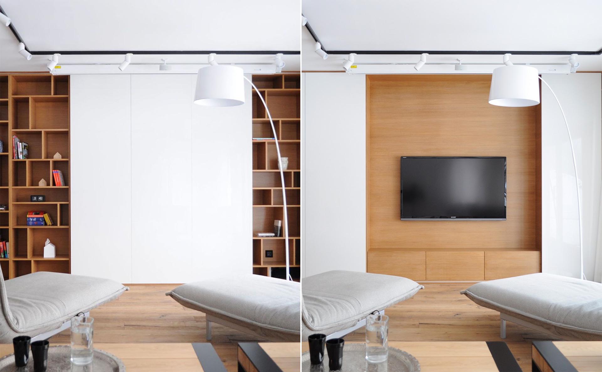 A TV is hidden behind sliding white wall panels in a living room.