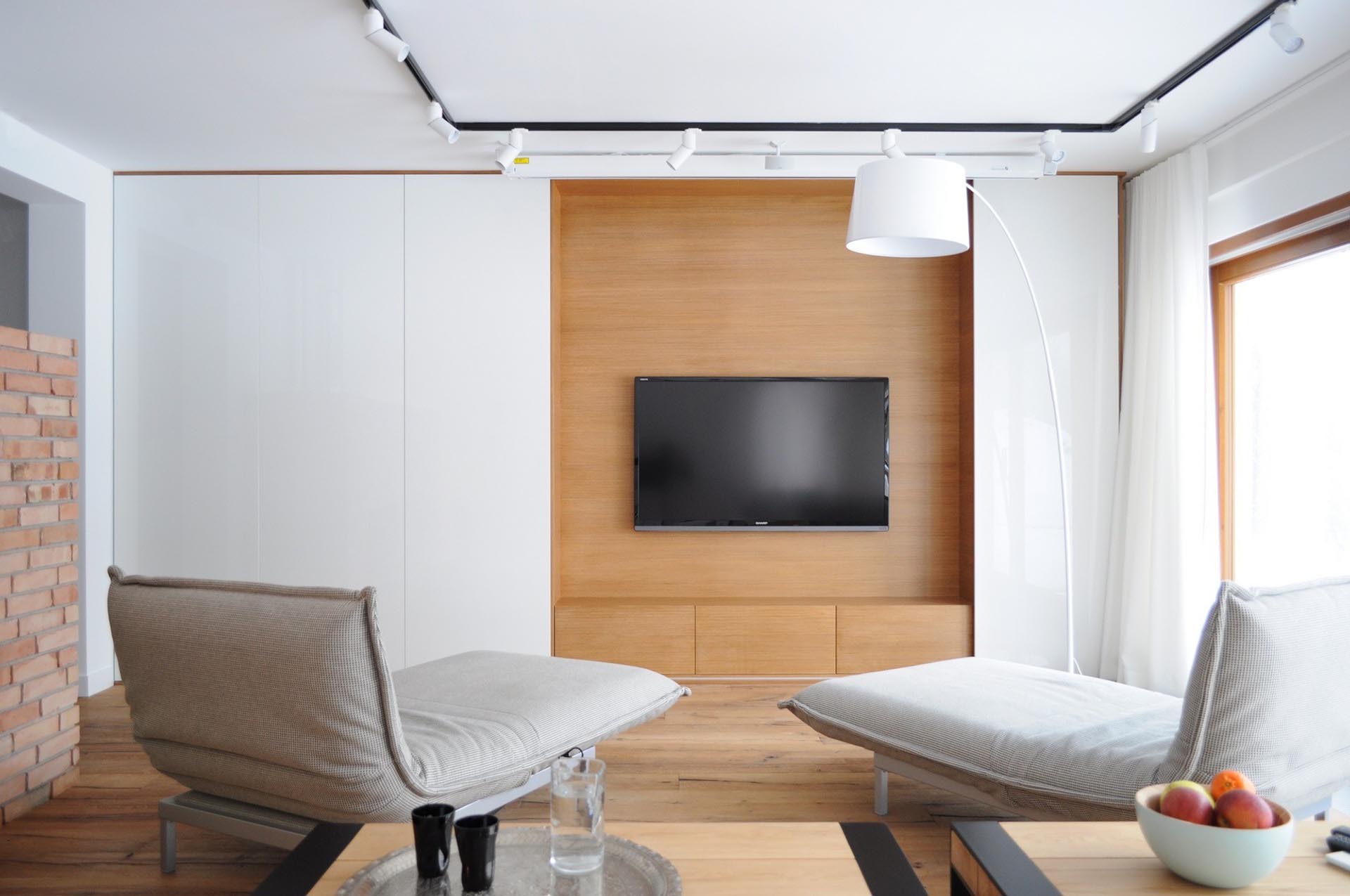 Sliding white wall panels open to reveal a hidden TV.