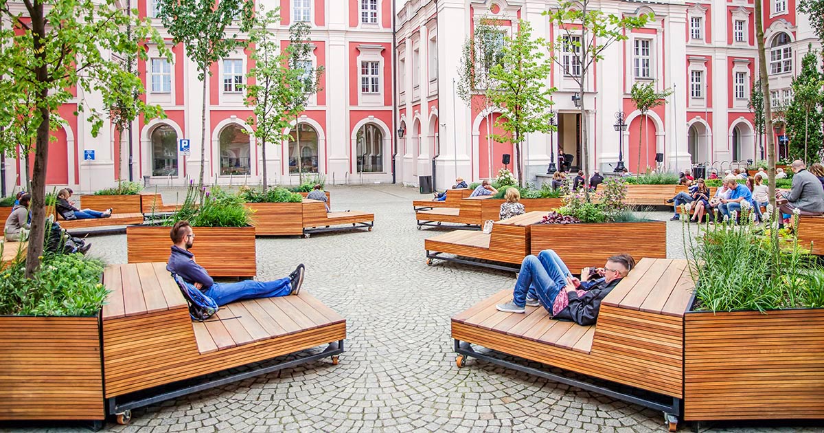 Triangular Planters And Mobile Wood Benches Fill This Courtyard