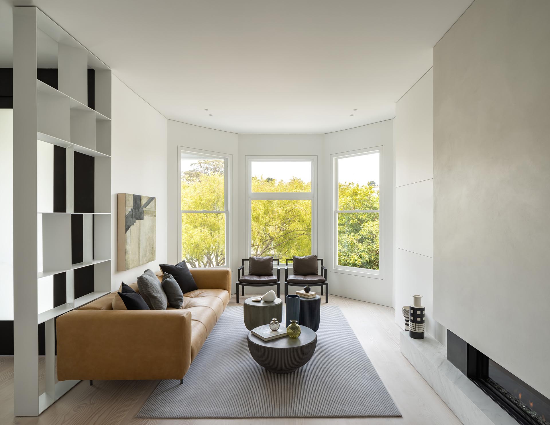 A living room with bay windows and a fireplace.