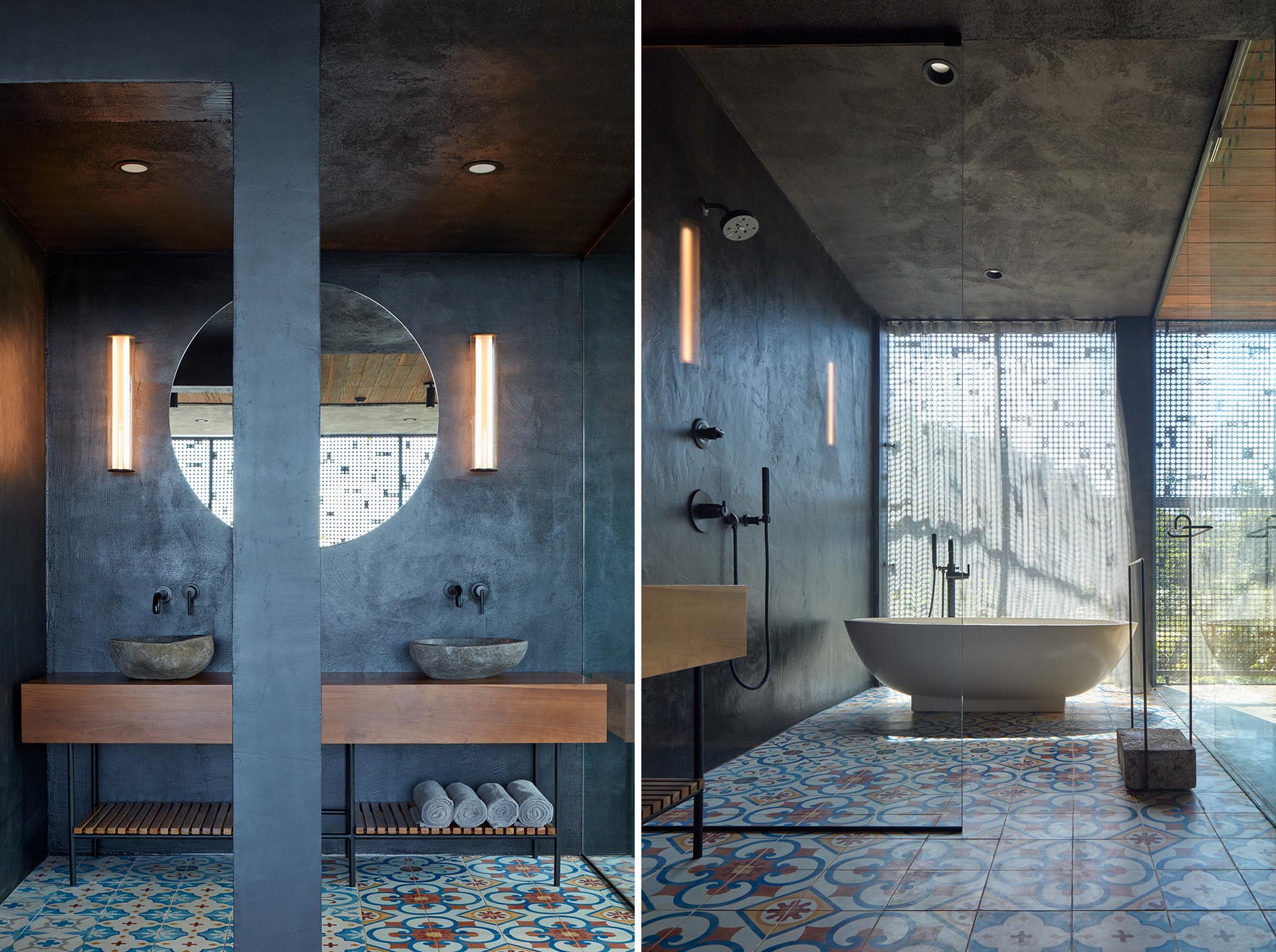 A grey bathroom with a freestanding bathtub and colorful patterned floor tiles.